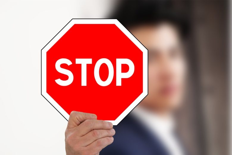 STOPの標識を掲げる男性